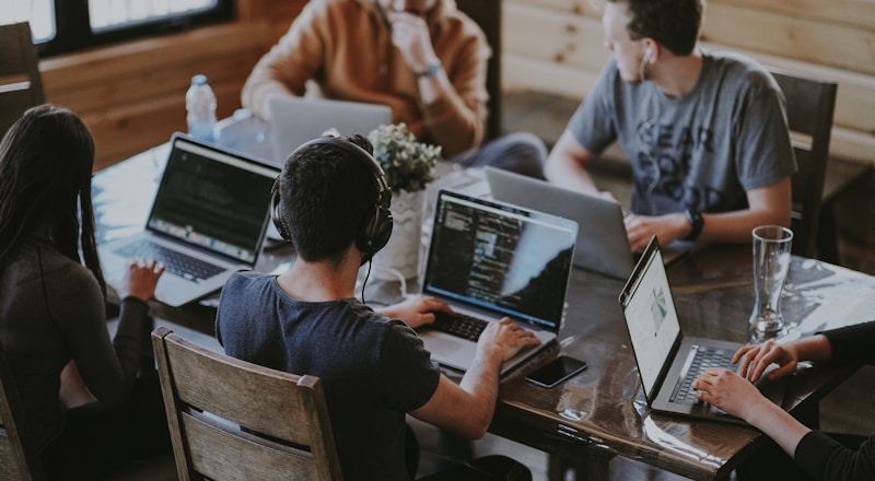 Team of strategists and engineers collaborating around a shared workspace